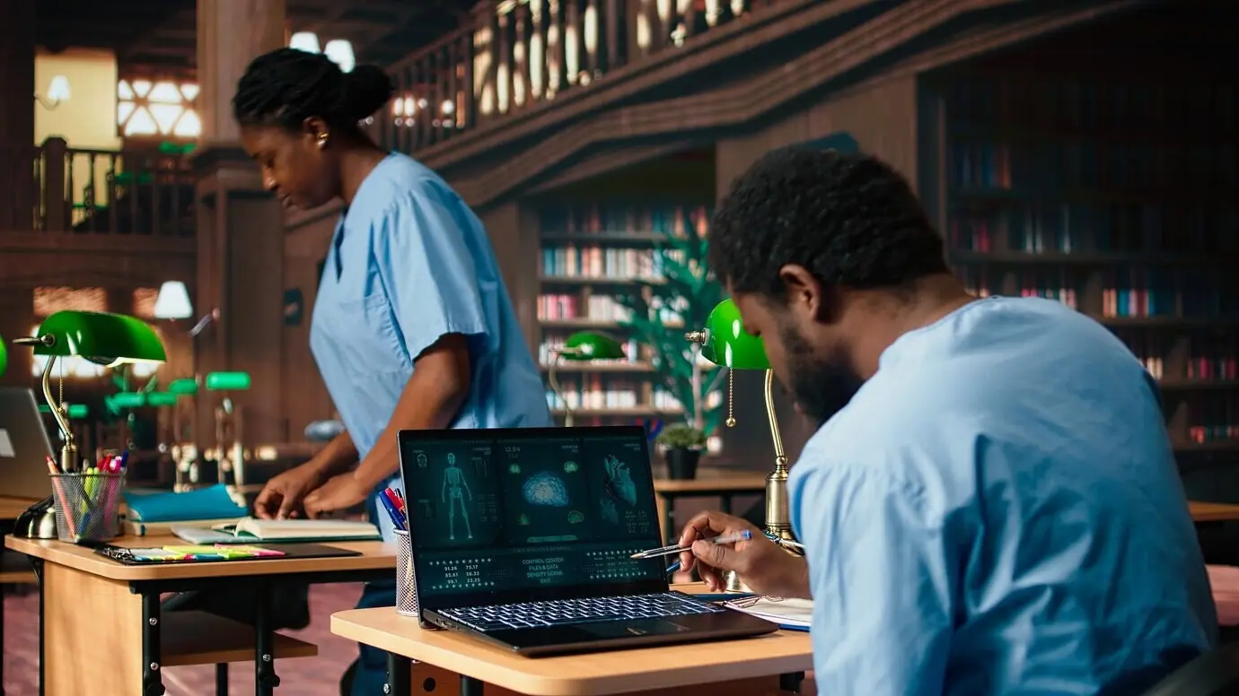 Un estudiante de medicina toma apuntes personales a partir de artículos de investigación sobre anatomía.